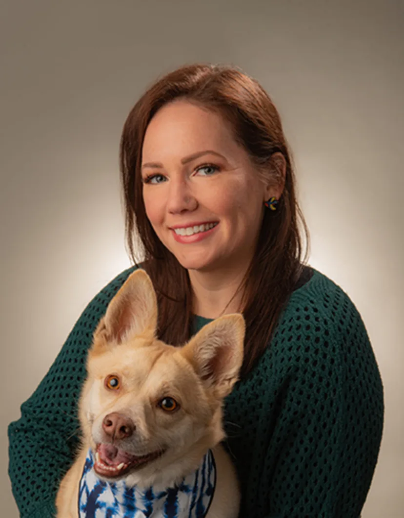 Melissa Mazur holding a dog with a bandana